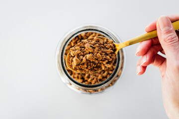 pantry staple close-up, spoonful of textured vegetable protein or dehydrated soy over clear glass...