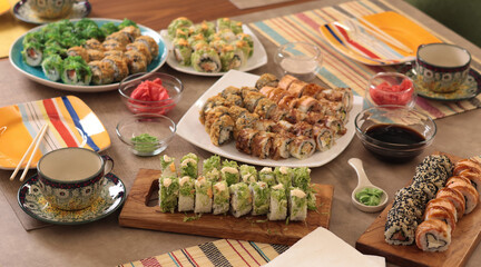 Sushi sets, sauce, wasabi, tea on party table. Food and traditional Asian cuisine. Table setting. 
