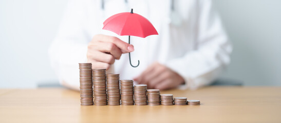 Doctor with Coins money stack growing with Umbrella cover. Money saving, Health Insurance, Medical...