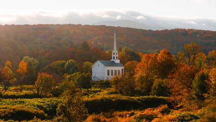 Naklejka premium Stowe Vermont New England Small Town Church Steeple Fall Foliage Autumn Season. Travel Tourism in October USA Colorful Forest Main Street Visit Travel