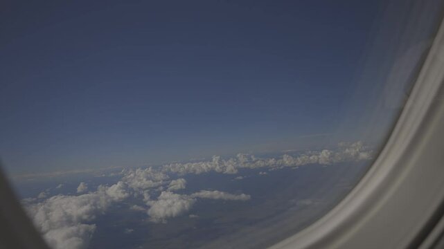 view from an airplane window, beautiful white clouds from above, captured canon eos R, raw c-log 8bits colour.