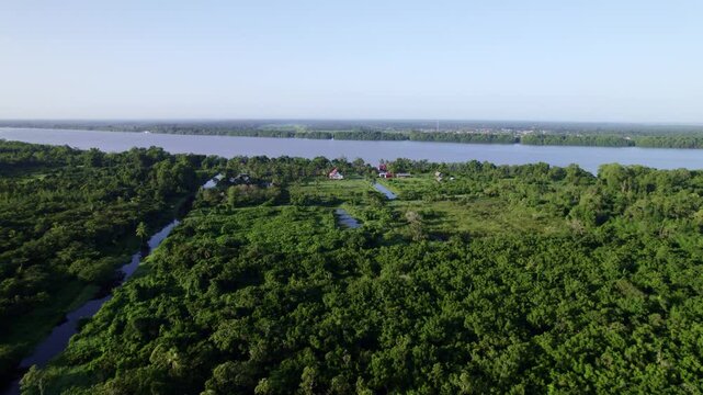 Drone flyover Frederiksdorp over Commewijne river, Suriname rainforest