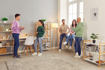 Company of cheerful smiling people friends or coworkers meeting in the living room together,...