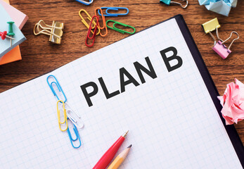 A Business Plan B Written On A Notebook With Pens And Paperclips