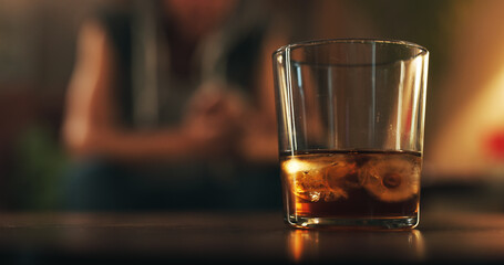 Alcoholic, addiction and glass of whiskey with person in living room for substance abuse, risk and depression. Mental health, wine and liquor with drink at home for temptation, withdrawal and control