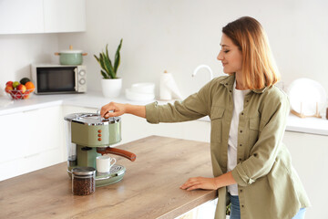 Young woman making coffee in kitchen