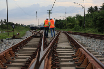 Senior male and female railway engineers are inspecting the railroad tracks for maintenance and...