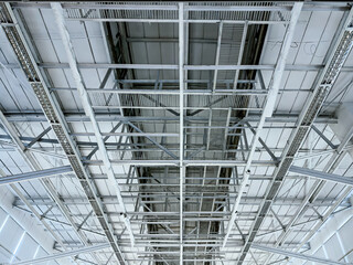 Fototapeta premium roof of large industrial building with steel beams structure. inside bottom view.