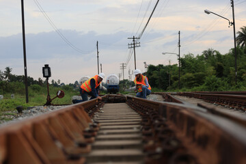 Senior male and female railway engineers are inspecting the railroad tracks for maintenance and improvements to ensure safe transportation of goods.