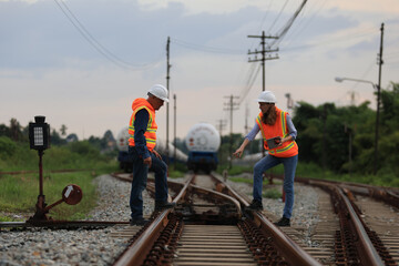 Senior male and female railway engineers are inspecting the railroad tracks for maintenance and...