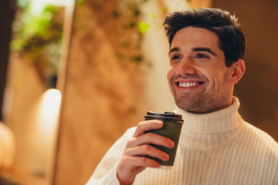Photo of dreamy attractive man dressed stylish clothes drinking coffee enjoying cozy weekend in cafe