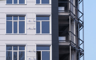 New windows on the white wall of the house. Light gray panels of a modern ventilated facade of the...