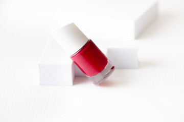 Minimalist nail polish bottle in red color on the podium on white isolated background for ads and product card, visula content market place