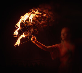 An enchanting fire dancer beautifully showcases her talent with mesmerizing flames during a...