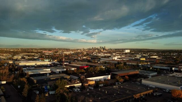 Sunrise drone shot of downtown Calgary surrounded by clouds.