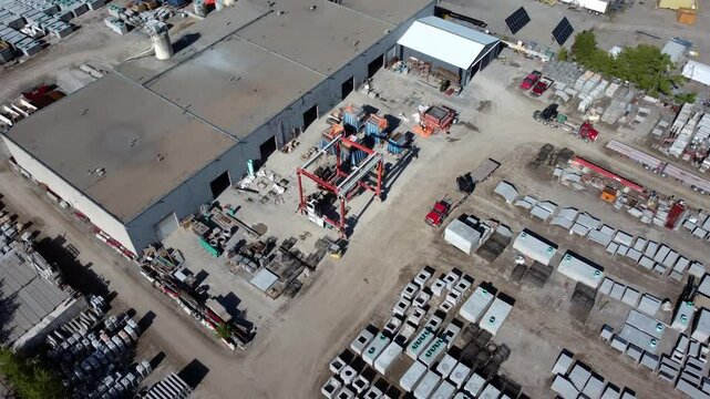 Drone view of a forklift carrying a pallet in an open-air warehouse in Calgary.
