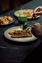 hand holding a plate with pizza