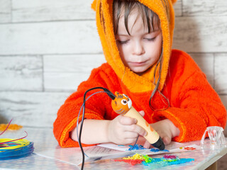 Children's hands make a craft using a 3D printing pen. A girl draws with a 3D pen.