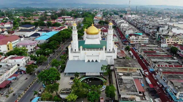 Aerial video across the golden roof of the grand mosque in Langsa City, Aceh