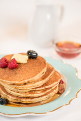 Stack of pancakes with berries and butter