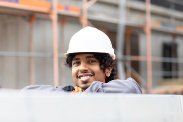 portrait, young technician  male with helmet and safety vest  working