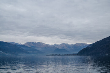 Cloudy evening sky above blue mountains reflected in the lake Como