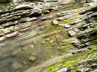 The river runs along the rocky cliffs in the mountains