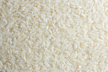 Dry Uncooked White Rice Background - Top View, Flat Lay. Scattered Raw Long Grain Rice. Asian...