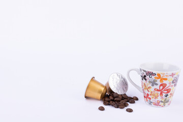 Golden Coffee Capsules and Beans with Coffee Cup on White Background