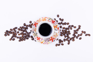 Coffee Cup and Saucer Surrounded by Coffee Beans on a White Background