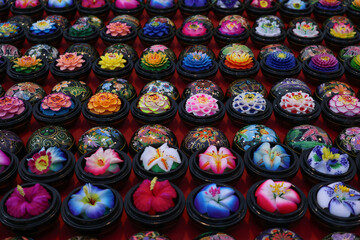 Street market in Thailand. Beautiful handmade fragrant soap in the form of traditional Asian flowers in stylized boxes for sell as souvenirs in the oriental bazaar.