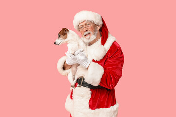 Santa Claus with cute Jack Russell Terrier dog on pink background