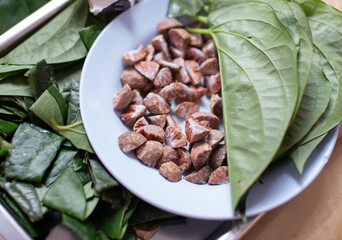 Areca nuts and betel leaves placed on a plate, close-up photo
