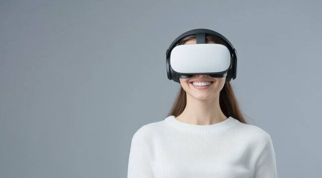A woman wearing virtual reality headset smiles joyfully, showcasing excitement of immersive technology. Her casual white sweater adds to modern, tech savvy vibe