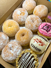 assorted homemade donuts. various taste of local donuts in a box. close up view of donuts in a box