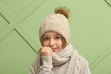 Cute little happy boy in winter clothes on green background