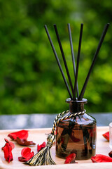 Closeup to a black bottle of aroma reed diffuser with green nature background