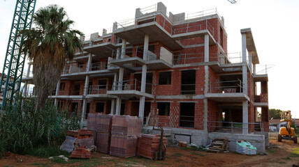 Construction progress of modern multi-story building in an urban area during daylight hours
