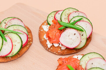 Crispy Cracker Sandwiches with Fresh Salmon, Cucumber, Radish, Cottage Cheese and Green Onions. Easy Breakfast. Quick and Healthy Sandwiches. Crispbread with Tasty Filling. Healthy Dietary Snack
