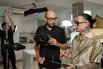 Team of videographers discussing working moments while preparing for shoot