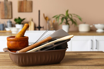 Utensils on wooden table in kitchen, closeup