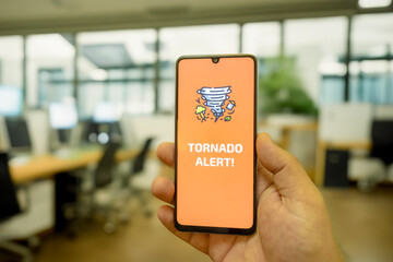 “Tornado Alert” message on the smartphone screen. Emergency alert. Smartphone screen and warning message.