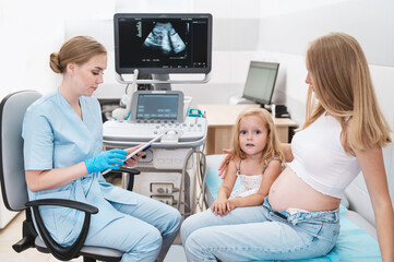 Happy doctor pregnant mother's ultrasound visit, sharing excitement with daughter who eagerly...