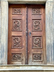 A photo captures a close-up of the architectural details of a wooden gate in the medieval historic city of Prague, Europe.