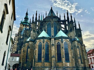 Fototapeta premium This photo captures the architectural charm and landscape of Prague’s medieval cityscape bathed in the warm glow of a summer sunset, highlighting its timeless beauty.
