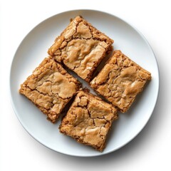 Four homemade blondie bars on white plate with cracked golden tops. dessert concept.