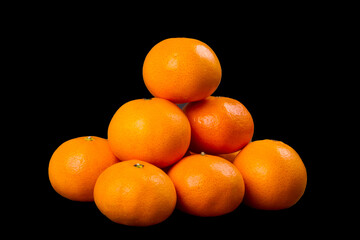 Fresh orange fruits on black background.