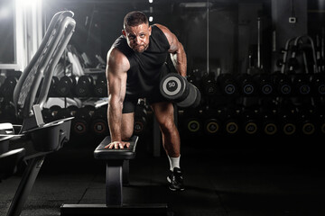 Muscular man having training with weights. Brutal strong athletic men pumping up muscles workout. Concept bodybuilder doing exercises in gym.