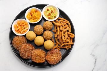 Indian festival food. Diwali Special sweet and salty snacks include Chakli, coconut laddu, besan ladu, poha and sabudana chivda, corn or maka mixture, Anarasa. Diwali Faral from Maharashtra, India.