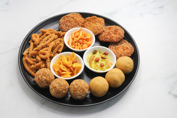 Indian festival food. Diwali Special sweet and salty snacks include Chakli, coconut laddu, besan ladu, poha and sabudana chivda, corn or maka mixture, Anarasa. Diwali Faral from Maharashtra, India.